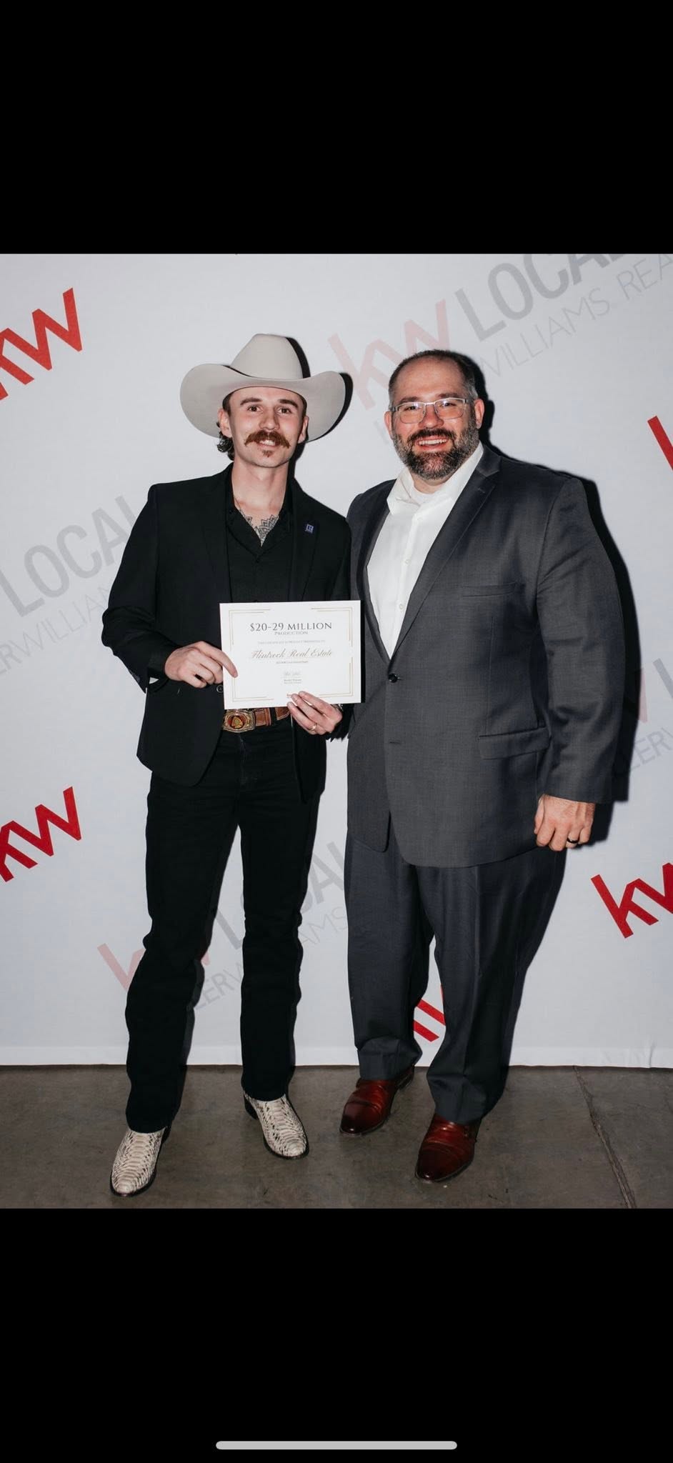 Brady Wells, lead auctioneer at QuickDraw Auctions, wearing a white cowboy hat and black suit